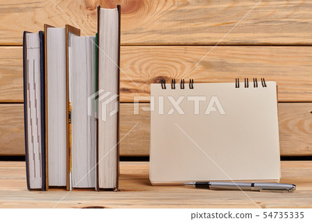 Books and spiral notepad on wooden background. Books and spiral notepad on wooden background. 54735335