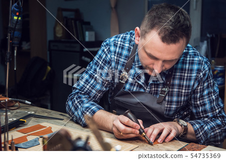 Concept of handmade craft production of leather goods. Concept of handmade craft production of leather goods. 54735369