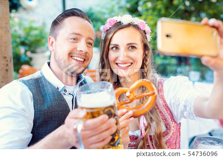 Couple in German beer garden taking a selfie picture with the phone 54736096