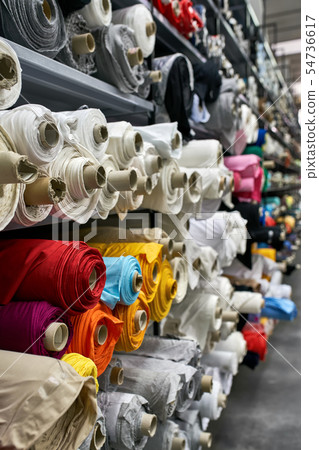 Fabric warehouse with many multicolored textile rolls Fabric warehouse with many multicolored textile rolls 54736617