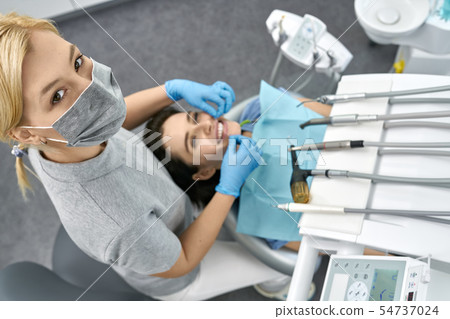 Pretty woman's teeth cleaning in dental clinic 54737024