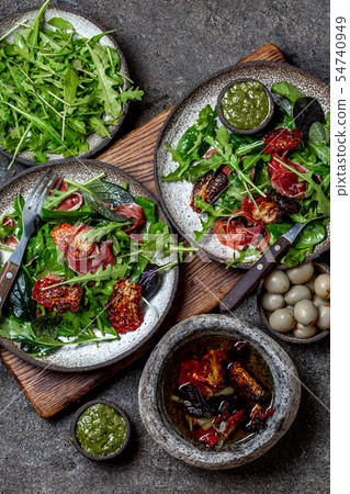 Salad with arugula, spinach, dried tomato and ham serrano paleta iberica. Low carbs keto recipe 54740949