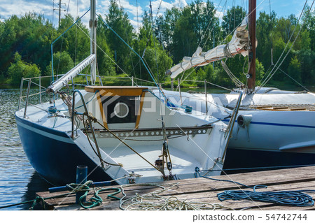 small yachts moored at a wooden pier small yachts moored at a wooden pier 54742744