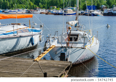 small yachts moored at a wooden pier small yachts moored at a wooden pier 54742745