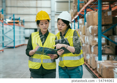 manager talking with worker in large warehouse 54744061