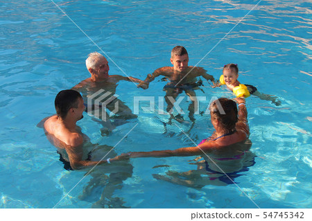 people swim in pool forming a circle. 54745342