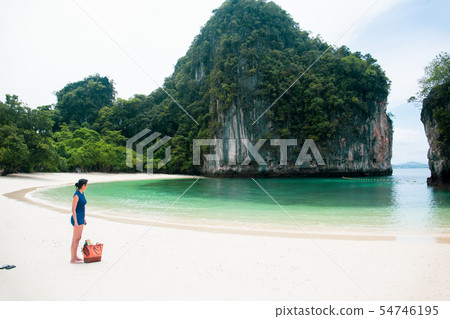 Woman standing on the beach looking at the sea with beachbag on vacation. Woman standing on the beach looking at the sea with beachbag on vacation. 54746195