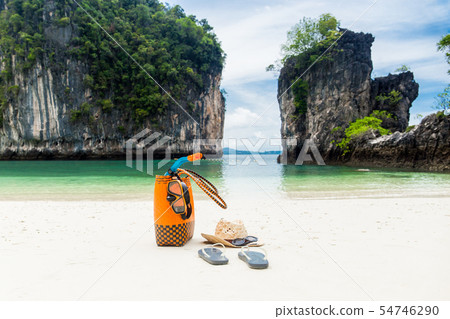 Beach bag with travel accessories on summer vacation. Beach bag with travel accessories on summer vacation. 54746290