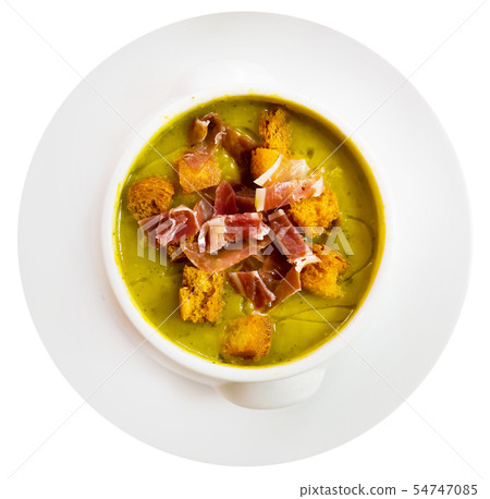 Top view of creamy zucchini soup with croutons and jamon 54747085