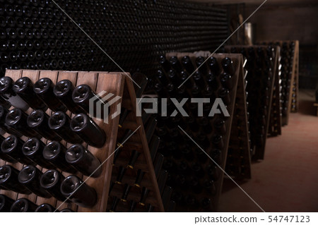 Wine bottles on racks in winery cellar Wine bottles on racks in winery cellar 54747123
