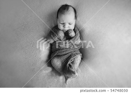 newborn baby sleeps wrapped in a blanket newborn baby sleeps wrapped in a blanket 54748030