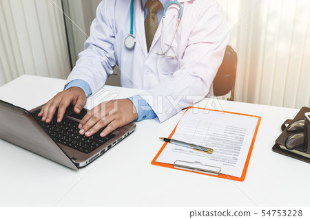 doctor typing at laptop computer doctor typing at laptop computer 54753228