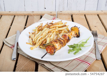 plate of French fries with a skewer of meat plate of French fries with a skewer of meat 54754287