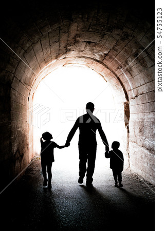 Father walking with his two children in a tunnel Father walking with his two children in a tunnel 54755123