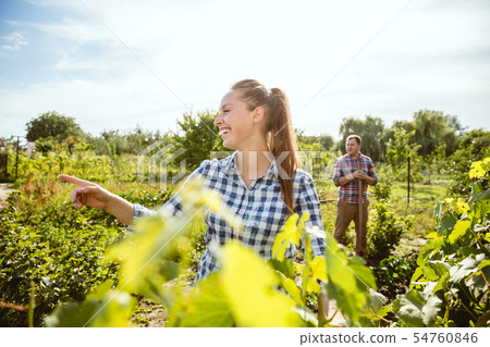 Young and happy farmer's couple at their garden in sunny day 54760846