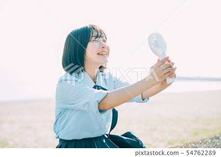 使用手持風扇的高中女孩 54762289