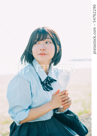 High school girl using a handy fan High school girl using a handy fan 54762290
