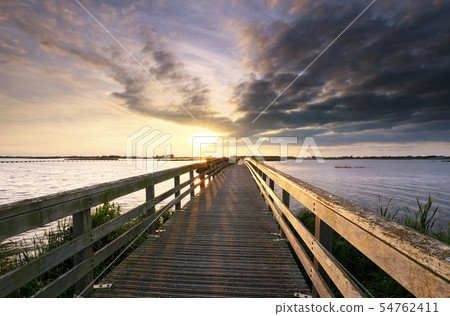 evening sunshine over wooden bridge 54762411