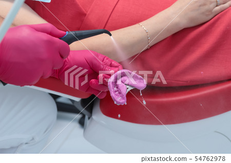 the dentist washes the impression with water 54762978