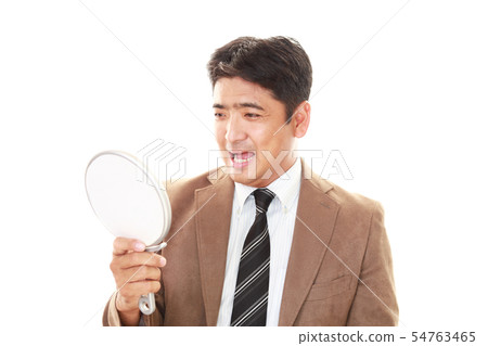 A smiling man with a hand mirror 54763465