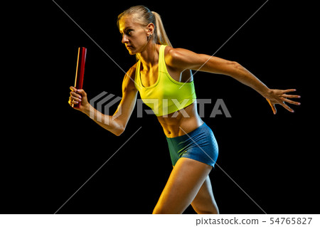 Professional female relay racer training on black studio background in neon light 54765827