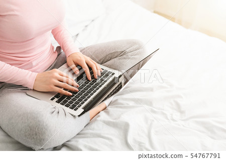 Woman journalist typing on laptop in bed 54767791