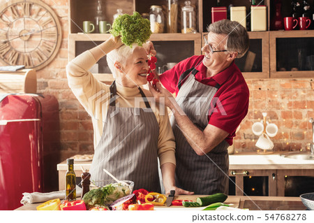 Senior man and woman using parsley and tomatoes like fashion accessories Senior man and woman using parsley and tomatoes like fashion accessories 54768278