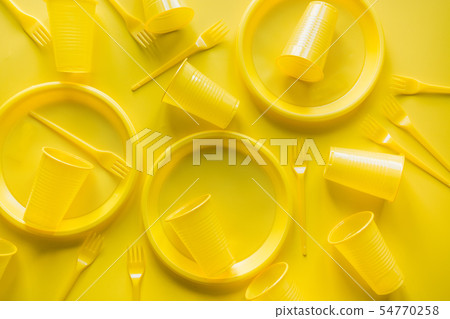 Yellow disposable picnic utensils. Top view. 54770258