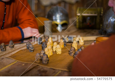 Two men playing popular strategy board game - tafl Two men playing popular strategy board game - tafl 54770575