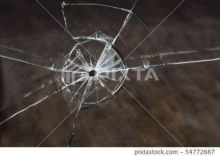Bullet hole in the glass after the shot Bullet hole in the glass after the shot 54772667