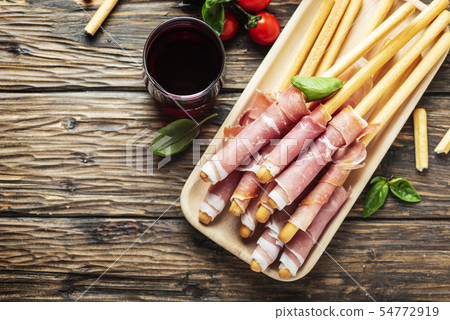 Italian antipasto with brad sticks and pork ham 54772919