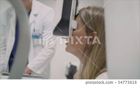 A beautiful girl is undergoing an ophthalmologic examination, checking her eye health and visual A beautiful girl is undergoing an ophthalmologic examination, checking her eye health and visual 54773818