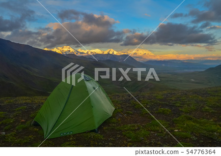Sunrise view of Mount Denali - mt Mckinley peak with alpenglow during golden hour with green camping 54776364