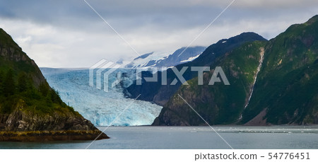 Distant panoramic view of a Holgate glacier with waterfall on the side in Kenai fjords National Park Distant panoramic view of a Holgate glacier with waterfall on the side in Kenai fjords National Park 54776451