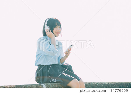High school girl listening to music near the sea 54776909