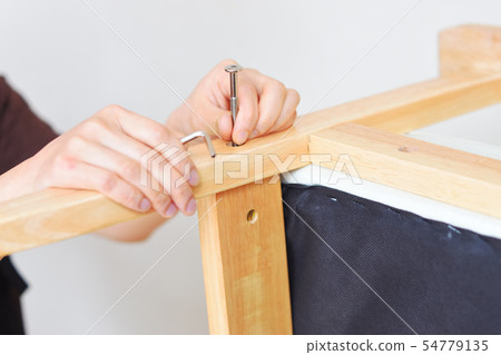 Woman assembling and disassembling the sofa Stop the bolt and loosen 54779135