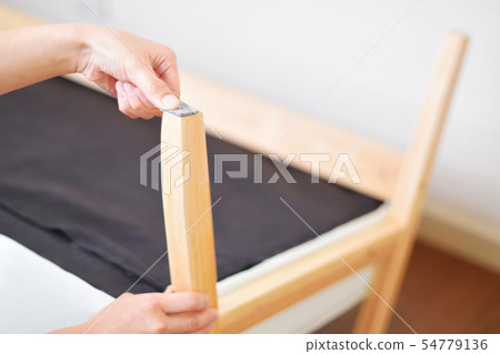 Woman assembling a sofa Anti-scratch felt Woman assembling a sofa Anti-scratch felt 54779136