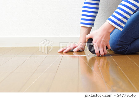 Woman measuring the size of DIY room Woman measuring the size of DIY room 54779140
