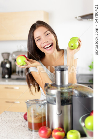 Apple juice on juicer machine at home in kitchen Apple juice on juicer machine at home in kitchen 54780421