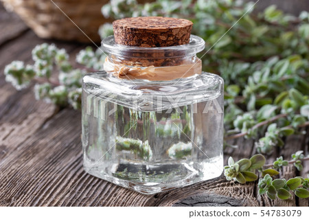 A bottle of marjoram essential oil with marjoram 54783079