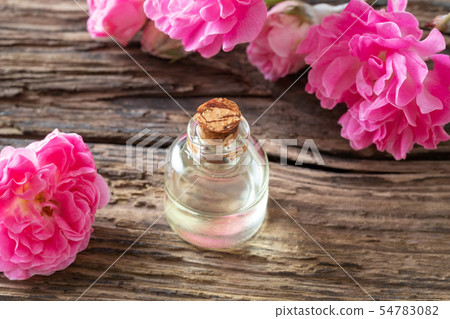 A bottle of essential oil with rose flowers 54783082