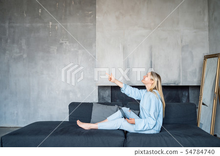 Image of happy woman using silver laptop while sitting on sofa 54784740