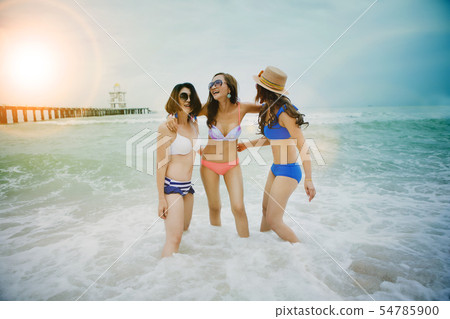 three woman happiness emotion with splashing sea three woman happiness emotion with splashing sea 54785900