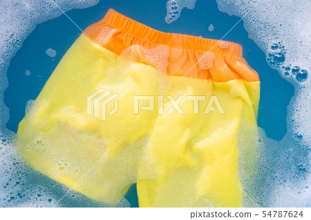 Yellow and orange baby shorts soak in water 54787624