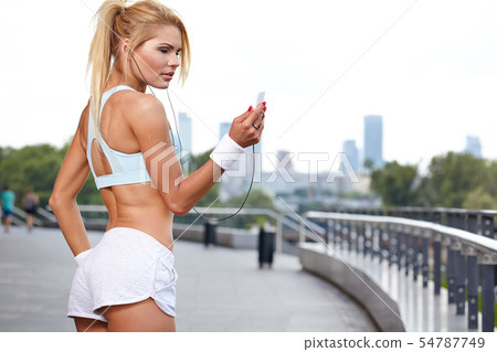 Beautiful woman during fitness on city is listen Beautiful woman during fitness on city is listen 54787749