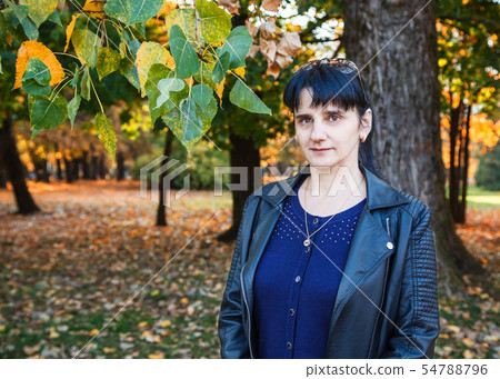 young brunette smiling woman on a walk in the park 54788796