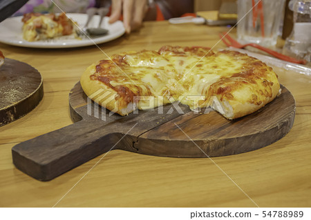 Pizza with ham and cheese on the wooden tray. Pizza with ham and cheese on the wooden tray. 54788989