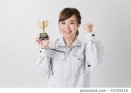 Business woman dressed in work clothes having a trophy Business woman dressed in work clothes having a trophy 54789439