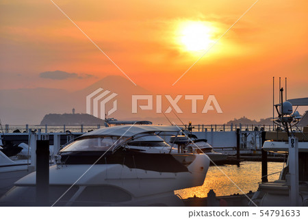 太陽落在一艘停泊在石獅碼頭的巡洋艦後面 54791633