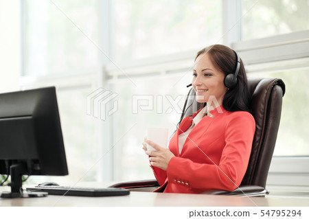 Young attractive woman in red jacket sitting on desk at head of executive in red jacket. Holds video Young attractive woman in red jacket sitting on desk at head of executive in red jacket. Holds video 54795294